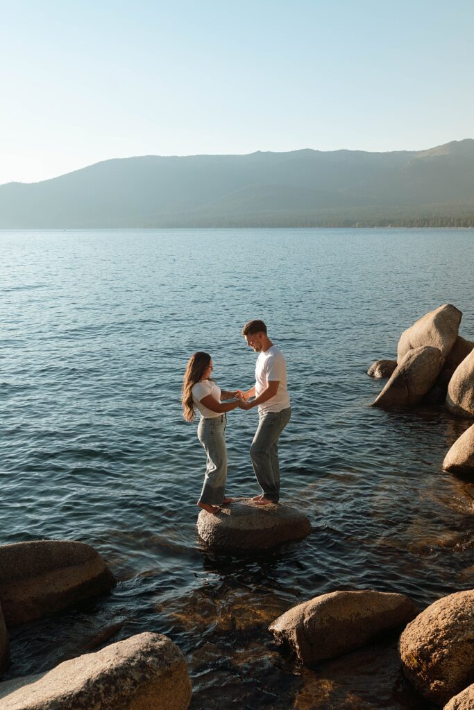 lake tahoe nevada engagement photos climbing on the rocks near sand harbor. lake tahoe engagement photographer
