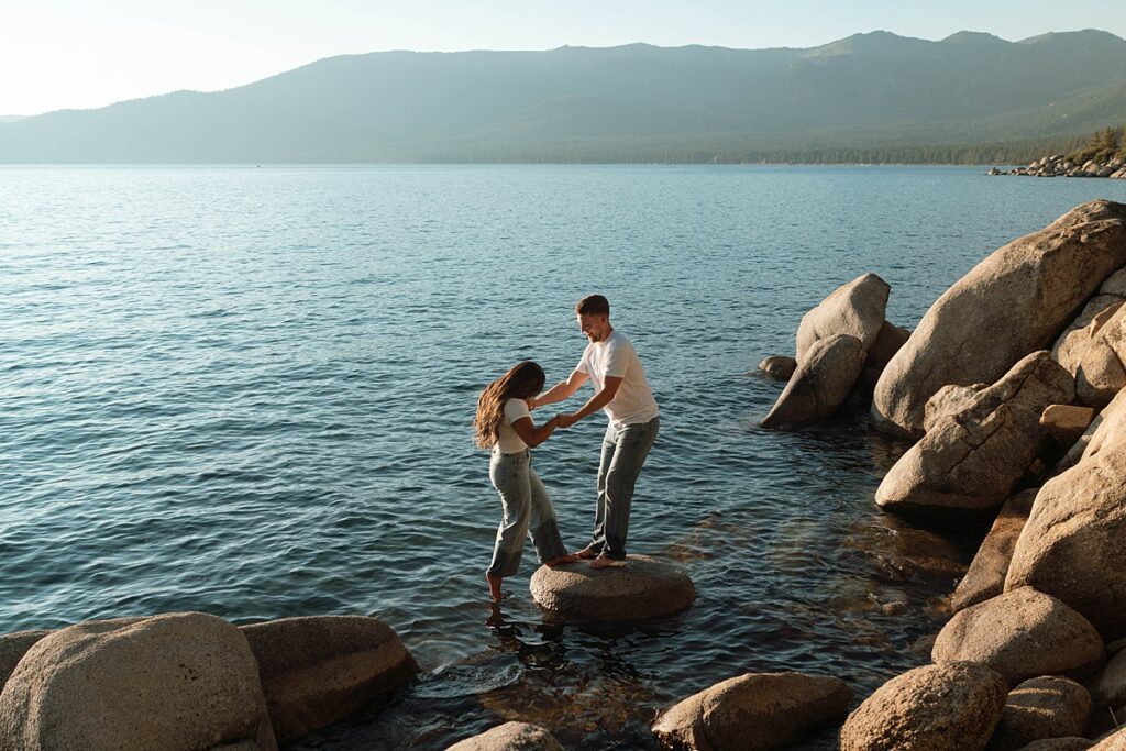 lake tahoe nevada engagement photos climbing on the rocks near sand harbor. lake tahoe engagement photographer