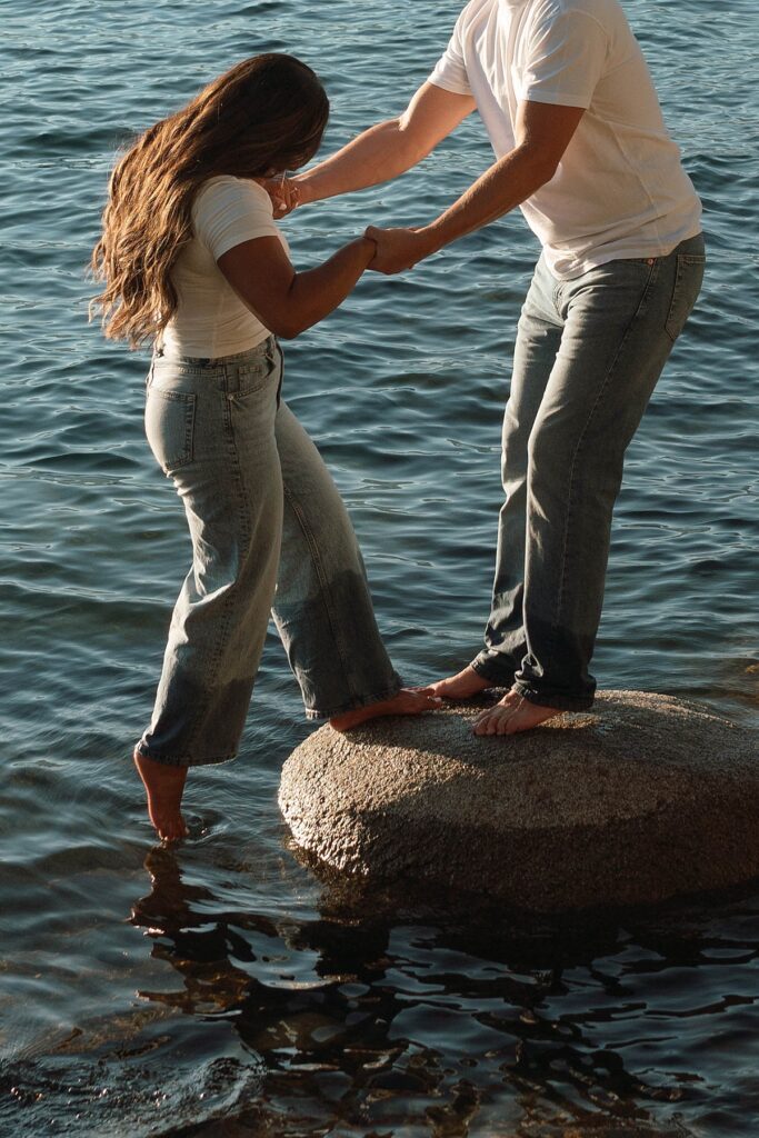 lake tahoe nevada engagement photos climbing on the rocks near sand harbor. lake tahoe engagement photographer