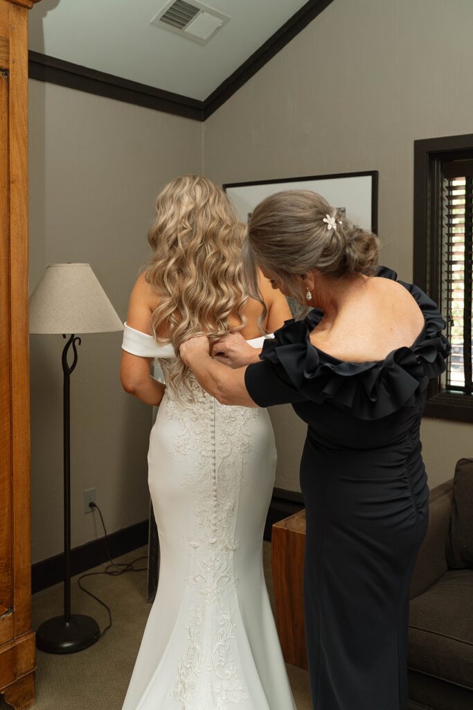 mom helping bride into her dress on her wedding day. Plumpjack inn Truckee Palisades Lake Tahoe Wedding photographer videographer
