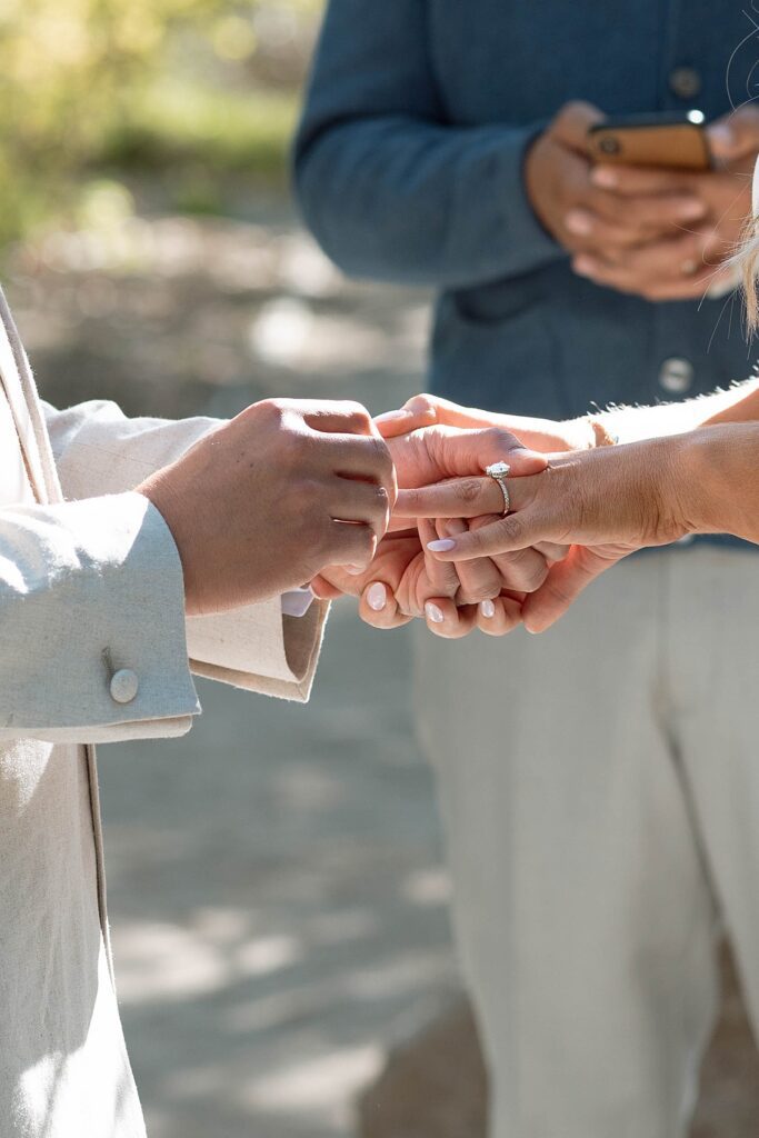 groom putting on the bride's ring at the ceremony.  Plumpjack inn Truckee Palisades Lake Tahoe Wedding photographer videographer