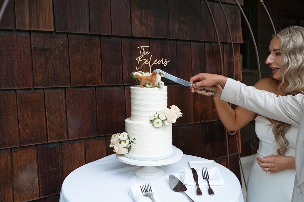 cutting wedding cake ceremony with bride and groom's dog as the cake topper. Plumpjack inn Truckee Palisades Lake Tahoe Wedding photographer videographer
