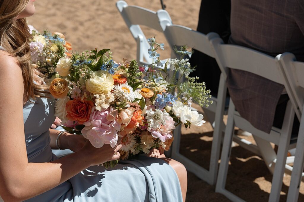 bridesmaids bouquets. sitting wedding party. Roundhill Beach Lake Tahoe Elopement Photographer Videographer 4JOY Media