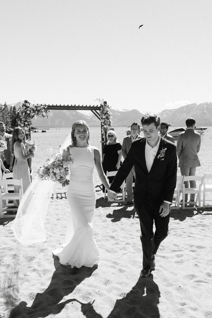 bride and groom walking down the aisle after I do. ceremony. Roundhill Beach Lake Tahoe Elopement Photographer Videographer 4JOY Media