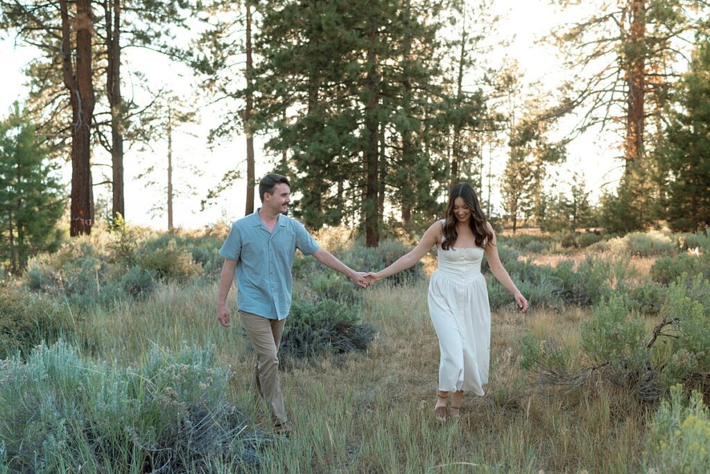 engaged couple walking in lake tahoe meadow