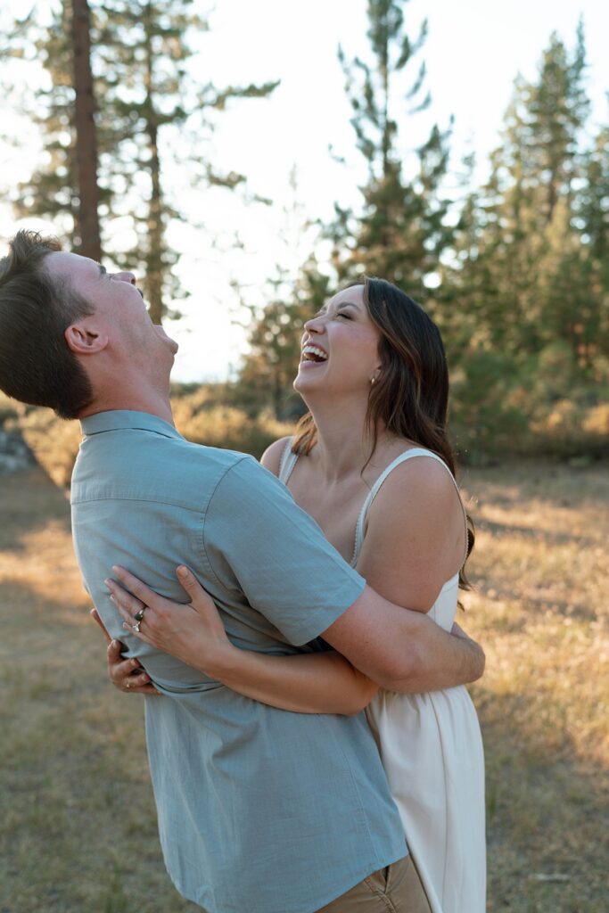 photographer captures an engaged couple laughing and embracing during their lake tahoe adventure session