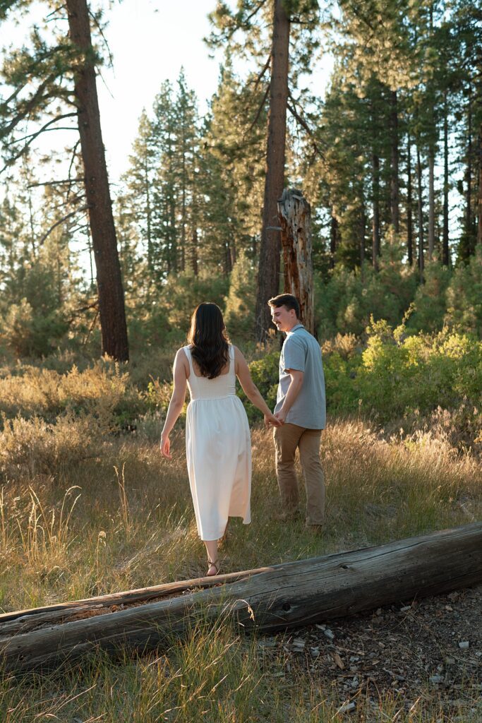 couple is photographed during their engagement session in lake tahoe in a meadow at zephyr cove 