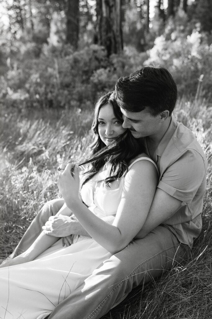 engaged couple embraces in the grass of a zephyr cove meadow 