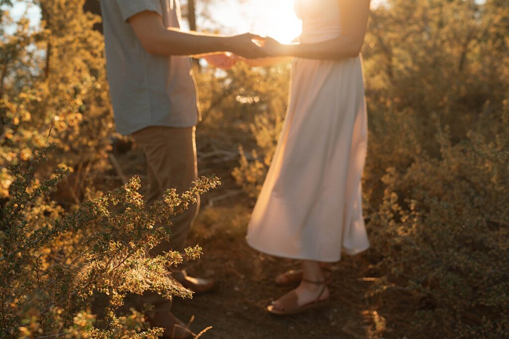 engaged couple holding hands captured in the golden sunset light by a lake tahoe photographer