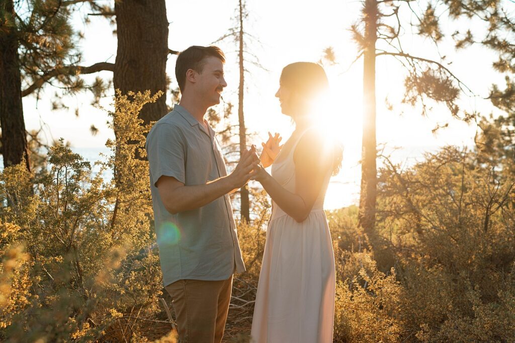 engaged couple holding hands captured in the golden sunset light by a lake tahoe photographer