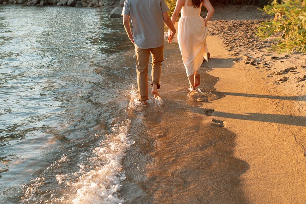 engaged couple walking on the beach during golden hour captured by lake tahoe wedding photographer 